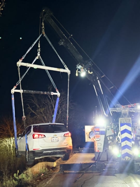 a tow truck lifting a SUV out of a ditch.