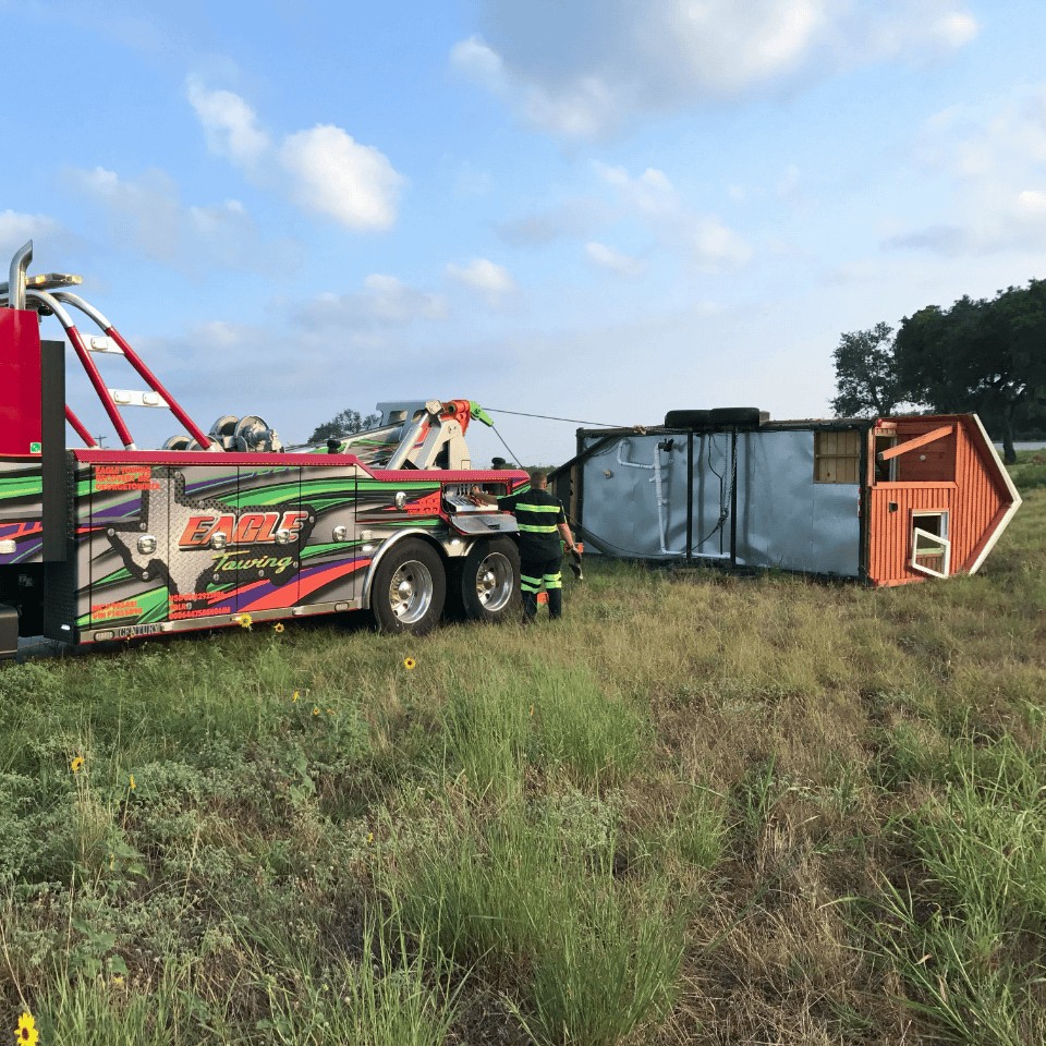 a tow truck Rescuing an overturned Mobile home.
