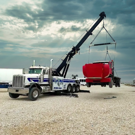 Tow truck lifting red truck