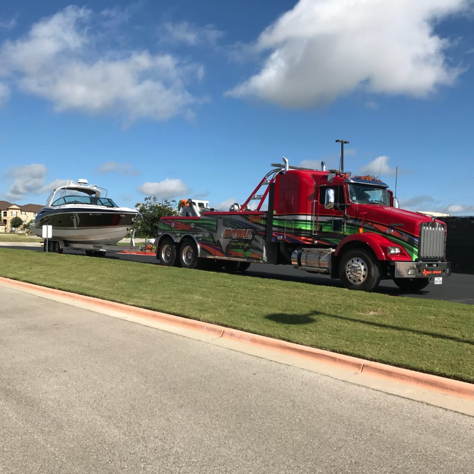 tow truck towing a boat.