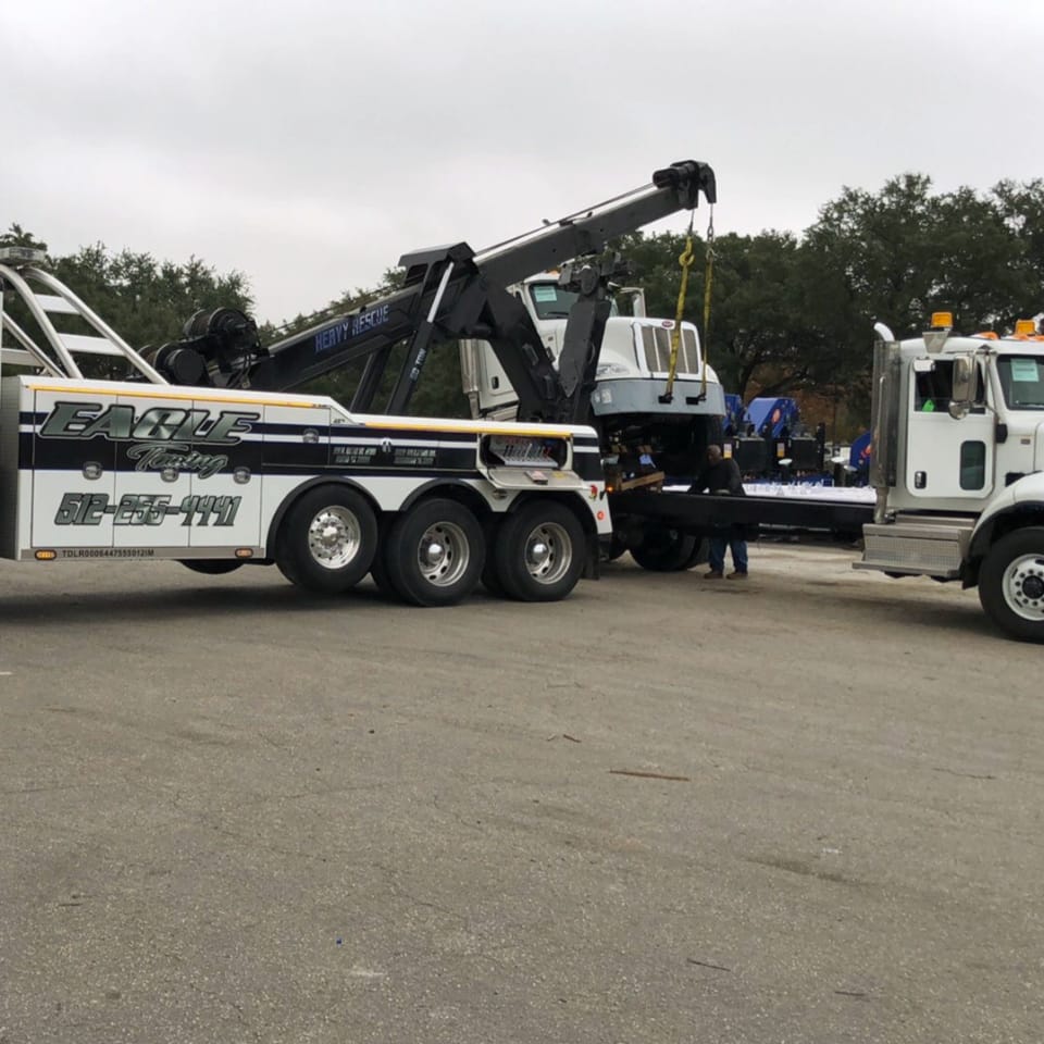tow truck towing a cab of a truck.